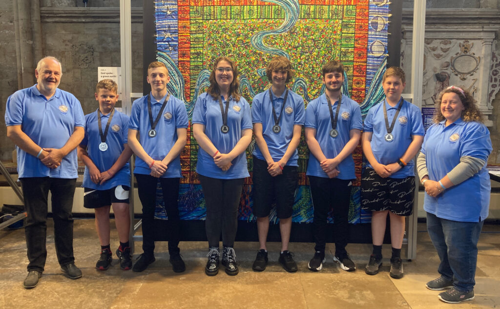 6 young ringers wearing medals, flanked by 2 adult helpers.